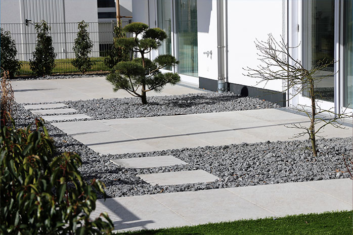 Aménager une terrasse moderne avec du béton, de la pierre et des plantations parcimonieuses 